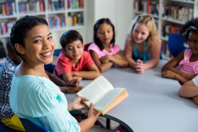 Teacher reading a book to a group of children in a library. Ideal for educational materials, school promotions, literacy campaigns, and children's book advertisements.