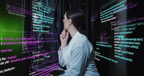 Female technician analyzing code in data center environment