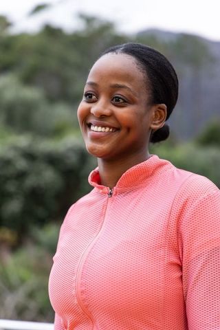 Smiling african american woman wearing pink textured zip-up jacket in park