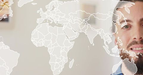 Bearded man with nose piercing looking past world map overlay for global business concept