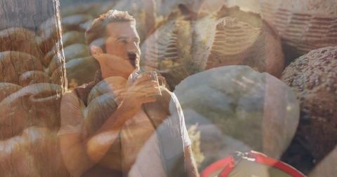 Mature camper sipping metal mug at rocky campsite with artisanal bread double exposure