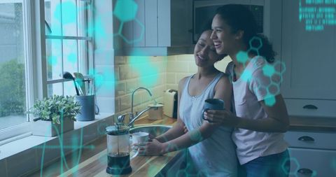 Two women embracing digital lifestyle in kitchen