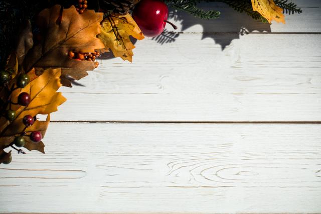 Christmas Decorations on Wooden Plank with Autumn Leaves and Berries - Download Free Stock Photos Pikwizard.com