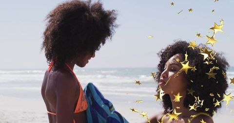 Mother and daughter sharing beach moment holding towel with gold star overlay