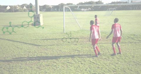 Youth soccer players walking toward goal on sunlit community field