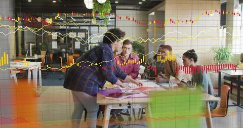 Team Collaborating Around Data Charts and Documents in Open Plan Office, Financial Graph Overlays