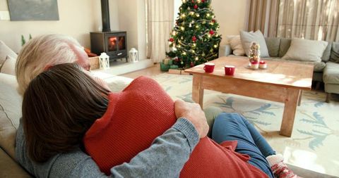 Senior couple embracing on sofa during christmas holiday at home