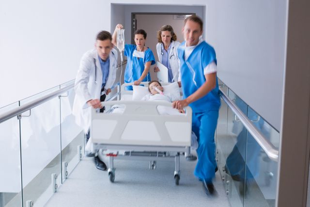 Doctors pushing emergency stretcher bed in corridor at hospital