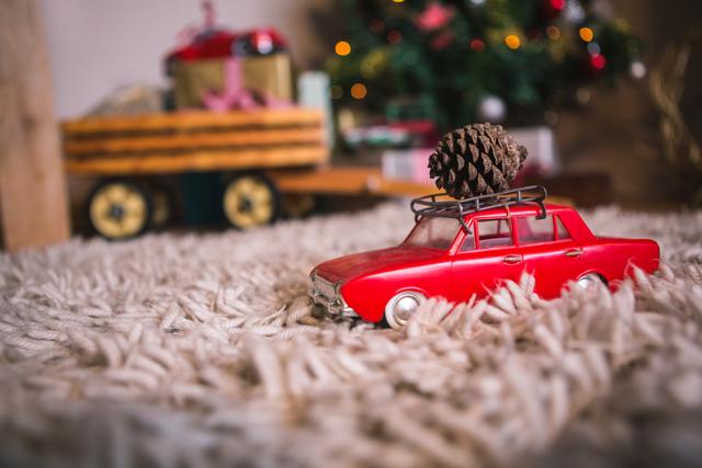 Toy car carrying christmas pine cone on fur carpet