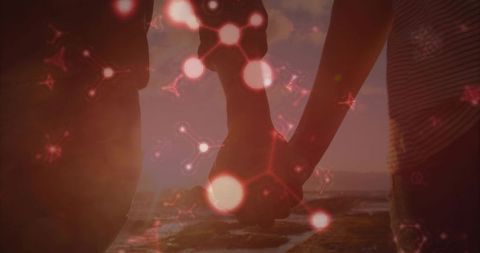Couple holding hands at sunset with abstract molecular graphics