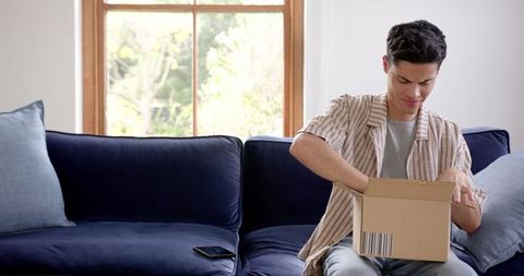 Happy man receiving and unboxing online order package
