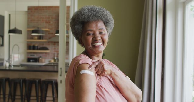 Smiling Elderly Woman Showing Arm After Vaccination at Home Near Window - Download Free Stock Images Pikwizard.com