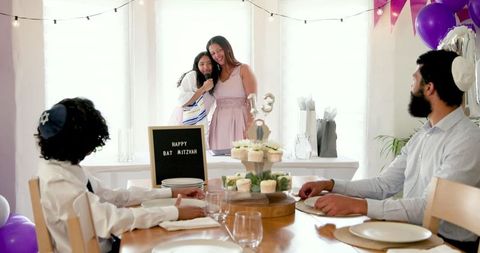 Family celebrating bat mitzvah with joyful gathering at home