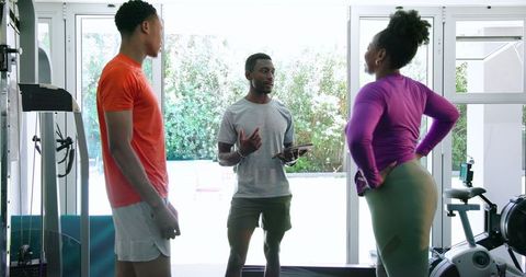 Personal trainer coaching couple at home gym session