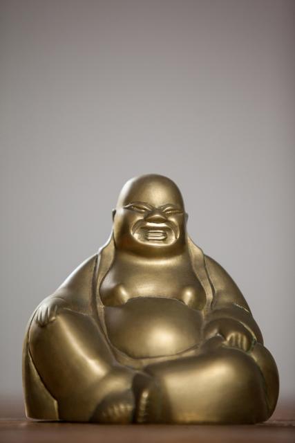 Gold Painted Laughing Buddha Figurine on Wooden Table - Download Free Stock Photos Pikwizard.com