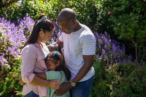 Diverse family embraces in lush flowering garden scene
