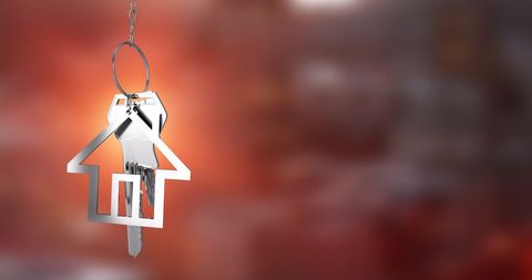 House-Shaped Keychain With Blurred Warm-Toned Background