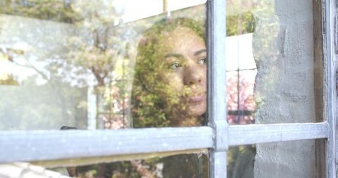 Woman Contemplating Through Window with Natural Reflections