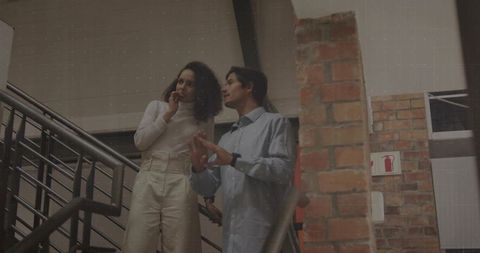 Coworkers Brainstorming on Staircase Near Brick Wall