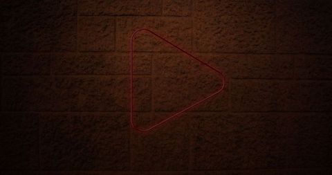 Neon triangle art installation on brick wall
