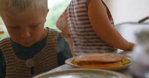 Caucasian Children Eagerly Awaiting Freshly Made Pancakes