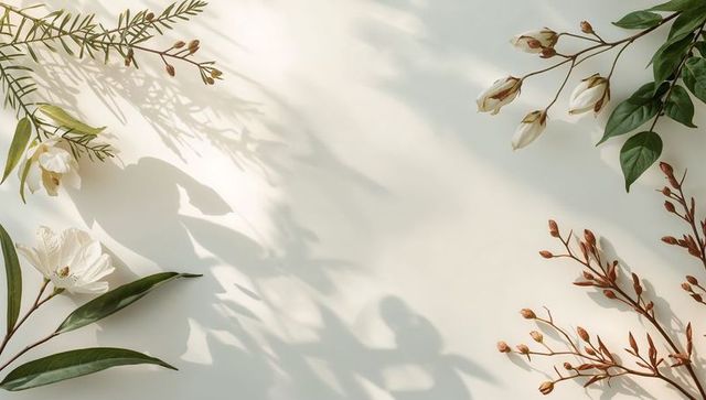 Soft cream botanical flat lay with white blossoms, green leaves and gentle shadows