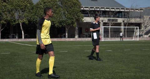 Youth soccer game in action on sunny day with lush green background