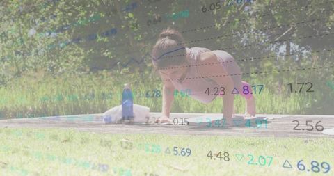 Woman doing push-ups outdoors on wooden platform wearing pink top with water bottle and towel