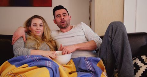 Couple Relaxing on Sofa Enjoying Movie Night at Home
