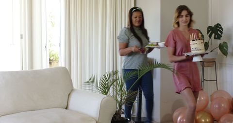 Friends Setting Up Vibrant Birthday Celebration in Sunny Living Room
