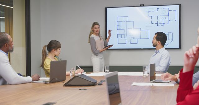 Mixed Team of Professionals Analyzing Building Plans in Modern Conference Room - Download Free Stock Images Pikwizard.com
