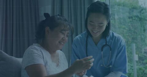 Smiling Nurse Assisting Patient With Medication at Home