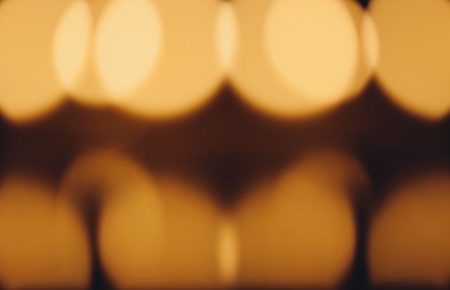 Abstract bokeh image featuring warm golden tones and soft, out-of-focus light glows. Perfect for use in design projects needing a dreamy, tranquil atmosphere, such as backgrounds for presentations, websites, or promotional materials. Ideal for creating a serene and warm ambiance.