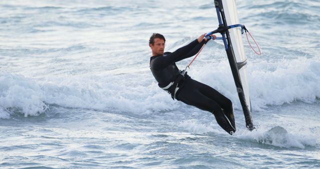 Man Windsurfing on a Sunny Day in the Ocean - Download Free Stock Images Pikwizard.com