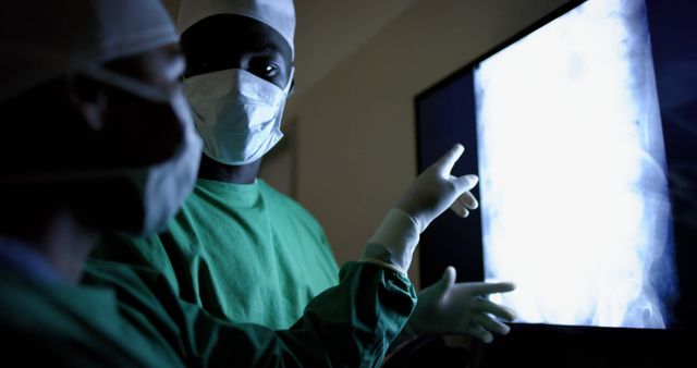 Doctors examining x-ray image pointing to spot of concern - Download Free Stock Images Pikwizard.com