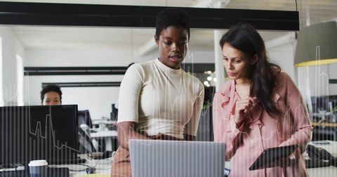 Diverse Business Team Analyzing Financial Data on Laptop in Office