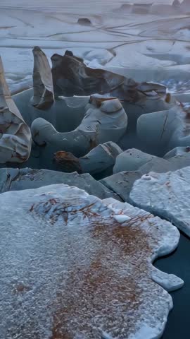 Drone Descending Over Frosty Arctic Floes Revealing Rusty Seaweed at Dawn