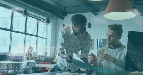 Diverse Professionals Collaborating Over Documents in Modern Office