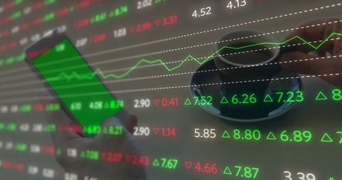 Smartphone with Green Screen Amid Stock Market Data Overlay
