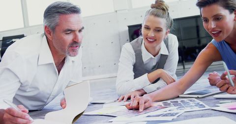 Collaborative team meeting with documents and color samples