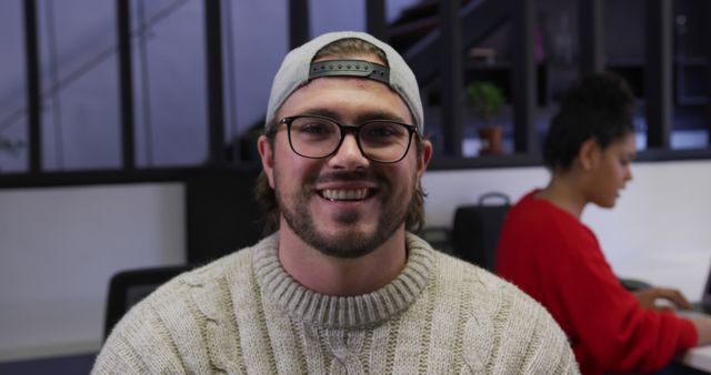 Casual Young Man with Cap and Glasses Smiling in Office - Download Free Stock Images Pikwizard.com