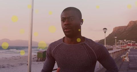 Fit man running on scenic promenade with earbuds