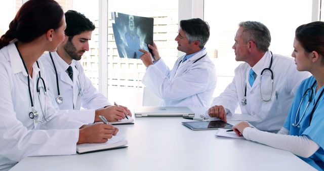 Medical team looking at x-ray during a meeting in the board room at the hospital