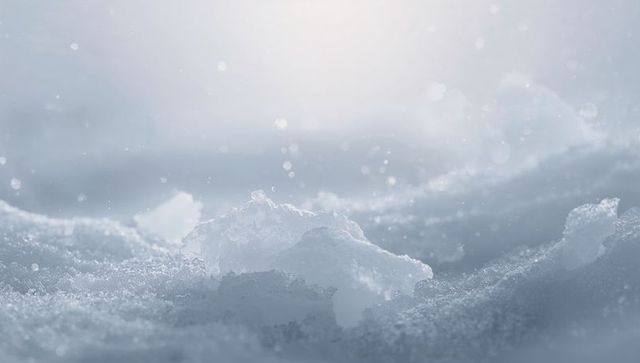 Backlit ice crystal sparkling on grainy snow macro frost bokeh texture for winter