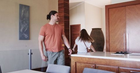 Couple embracing joyfully in modern kitchen setting