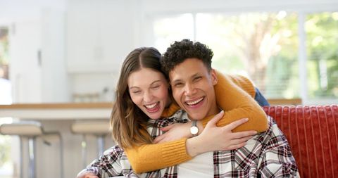 Joyful Couple Embracing on Living Room Sofa - Download Free Stock Images Pikwizard.com