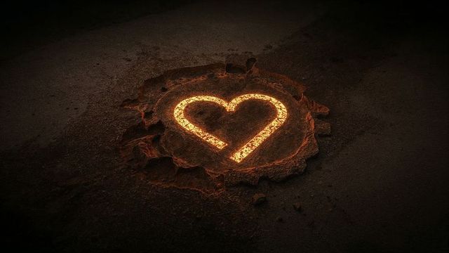 Glowing heart symbol in barren soil emanating fiery light