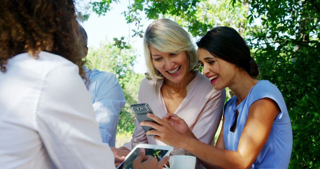 Women Relaxing at Outdoor Café Sharing Smartphone - Download Free Stock Images Pikwizard.com