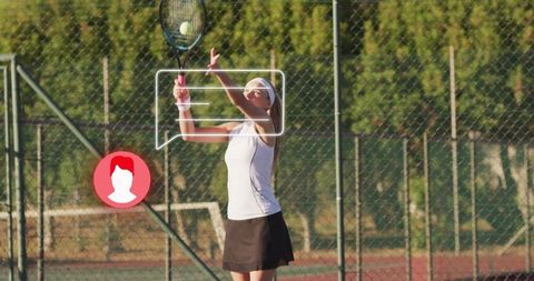 Female tennis player serving on outdoor clay court