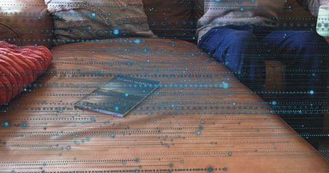 Man sitting on brown leather couch with paperback and blue digital scanline overlay